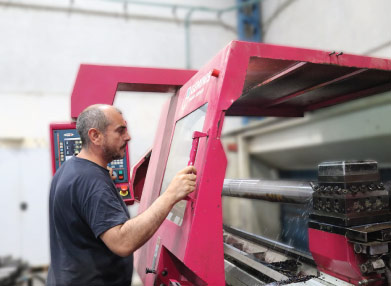 An NCCM employee working at a CNC machine